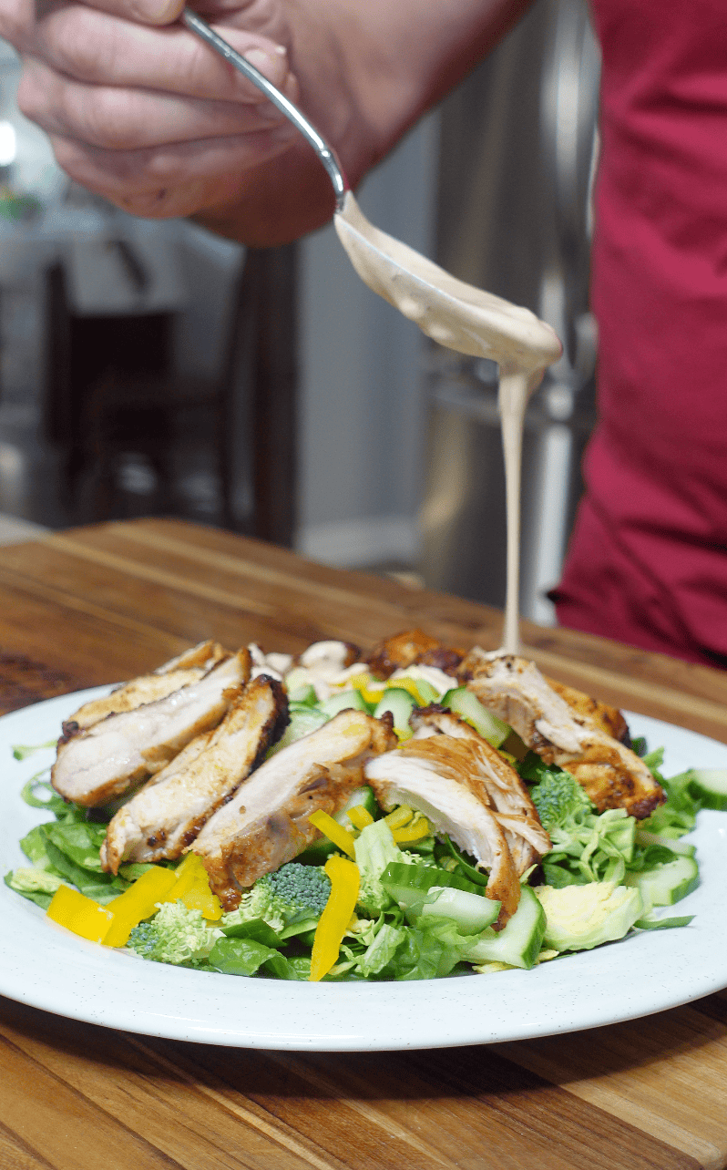 adding homemade ranch dressing to chicken salad