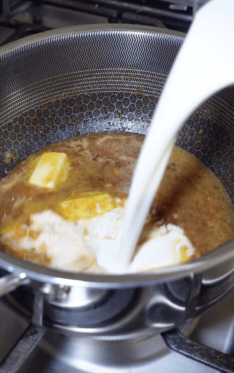 Melting butter with cream in a pot.