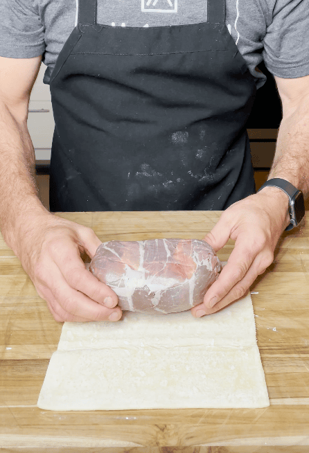 Wrapping the Wellington with puff pastry sheet.