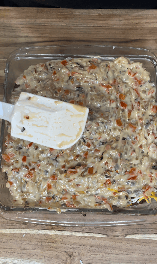 Spatula spreading mixture on casserole.