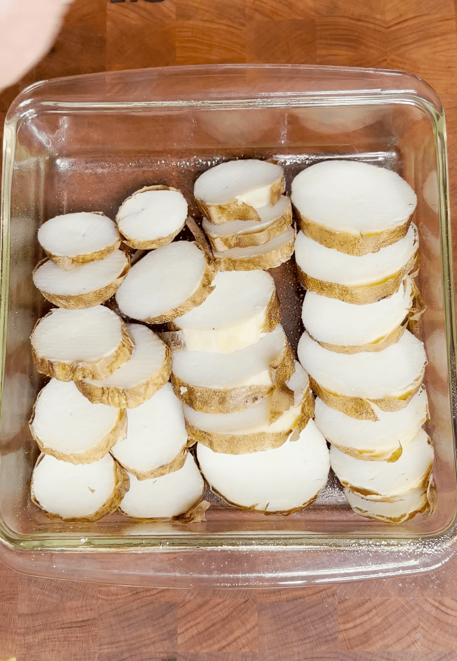A glass baking dish with sliced potatoes. 