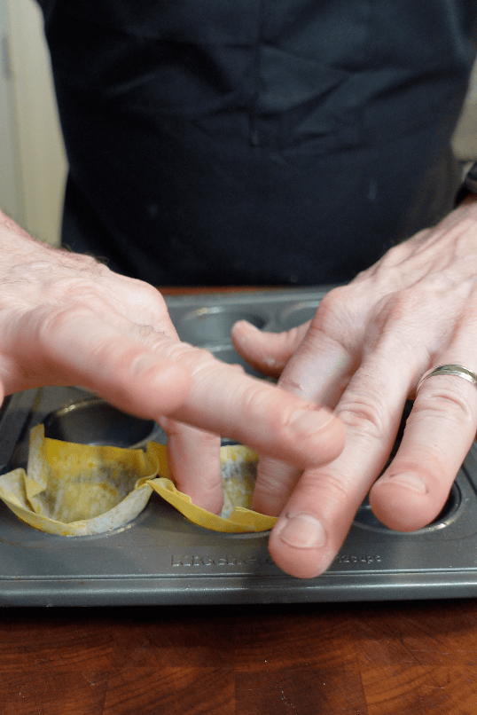 Wontons going into muffin pan.