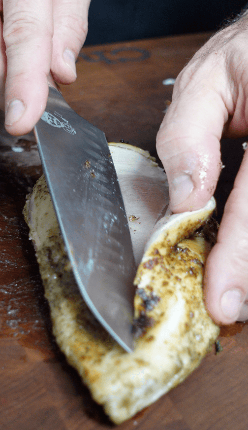 Chicken being cut in half.