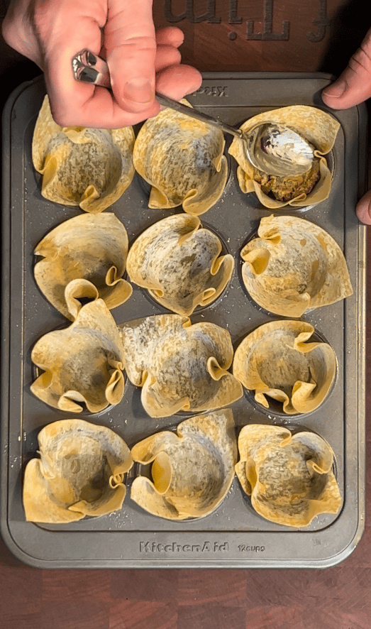 Wontons being filled with meat.