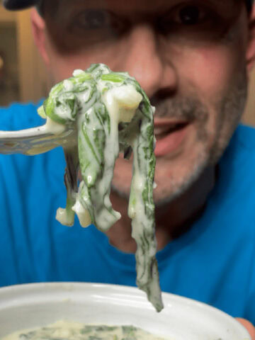 A scoop of creamed spinach on a fork.