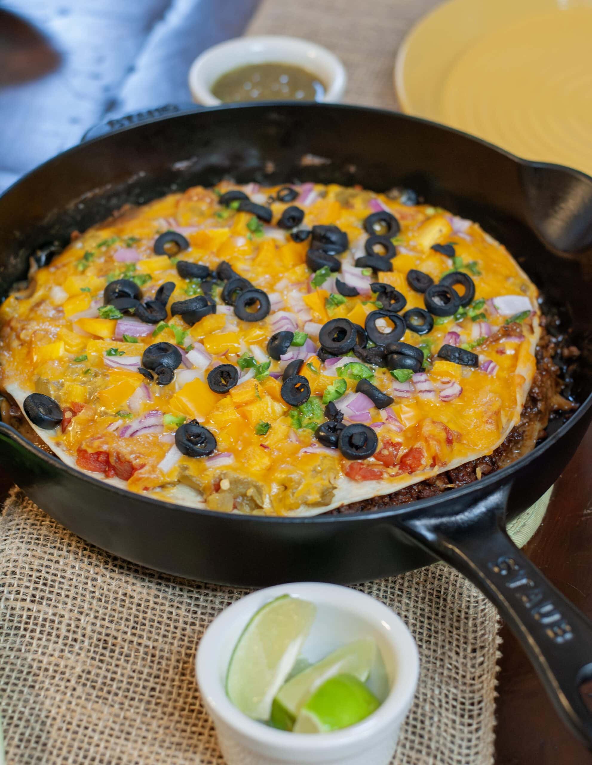Mexican Pizza with toppings in a cast iron skillet.