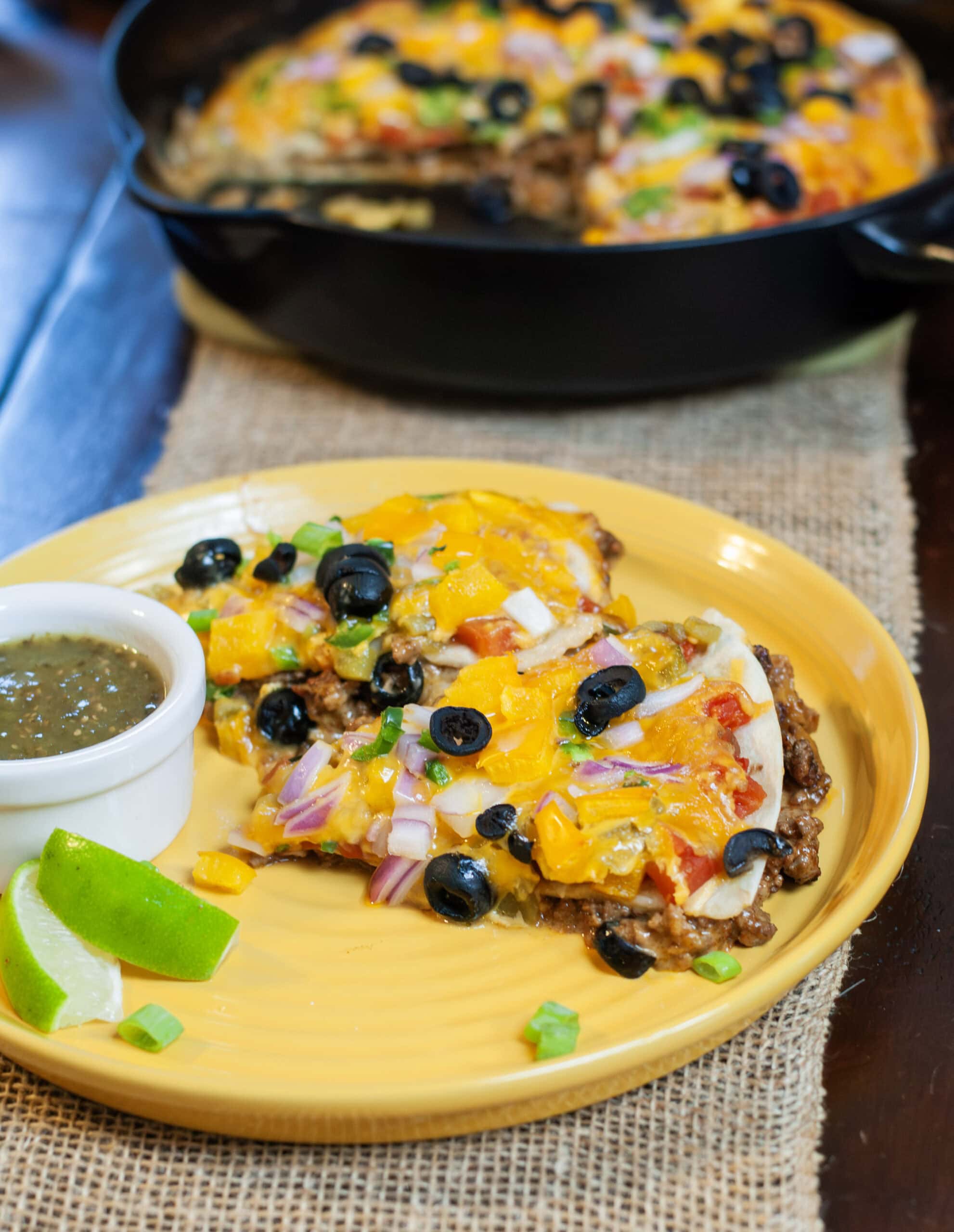 Mexican Pizza with toppings in a cast iron skillet.