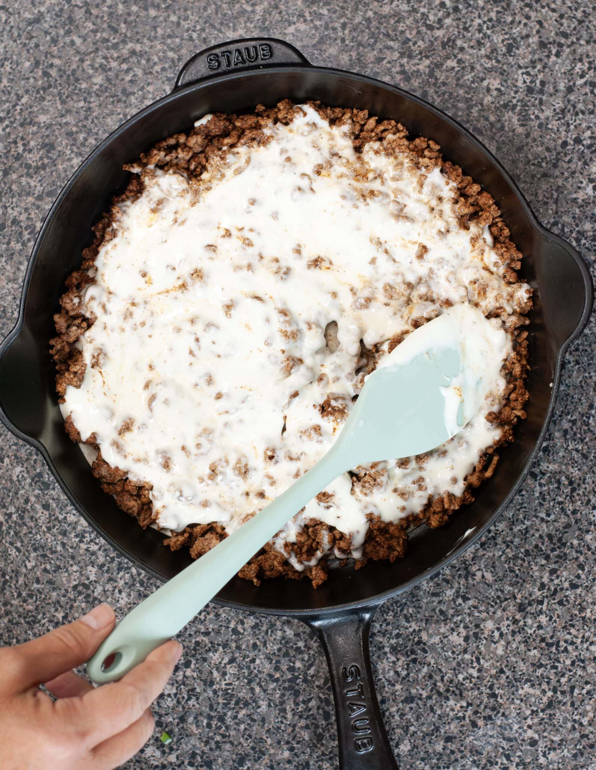 Queso spreading on ground beef.