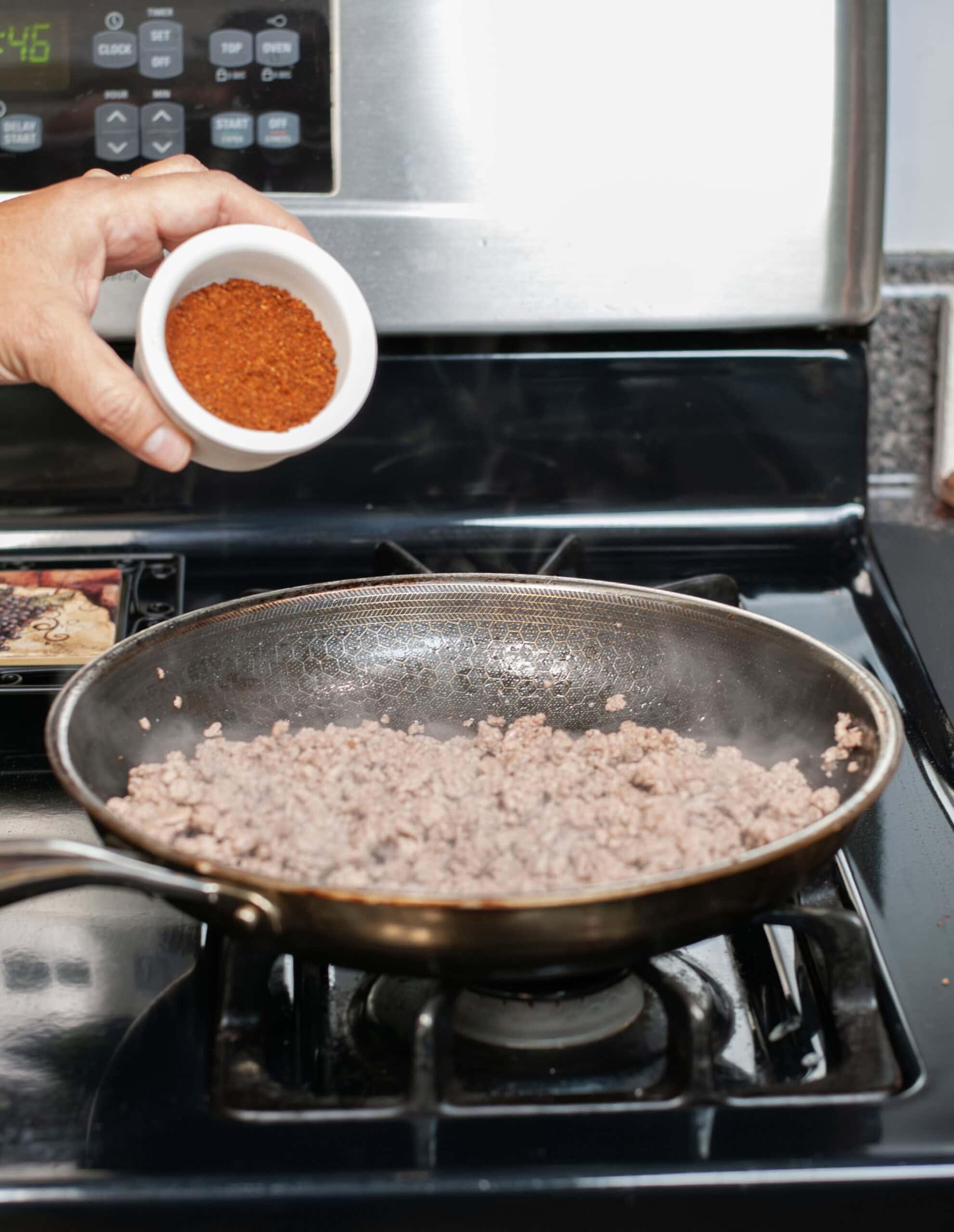 Seasoning meat with taco seasoning.