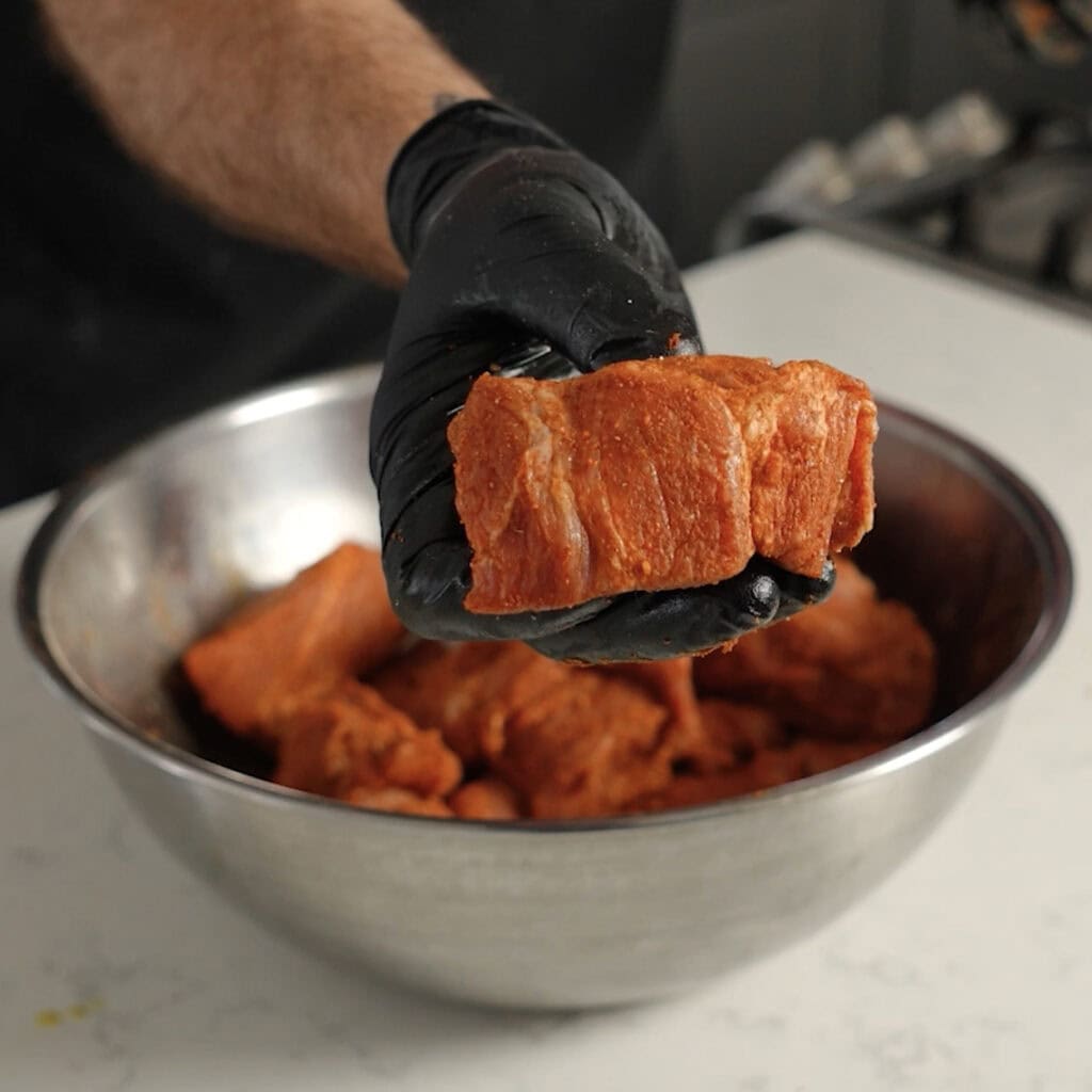Holding a Burnt End that's been seasoned.