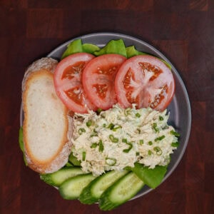 Chicken salad on a plate with vegetables.