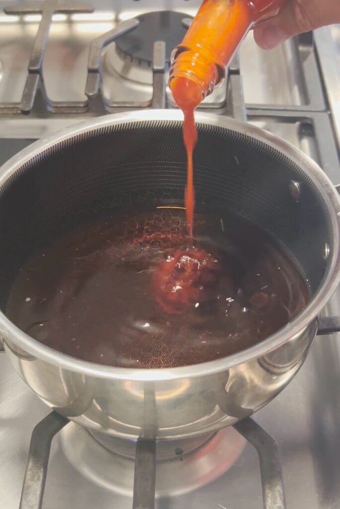 Hot sauce going in a pan.
