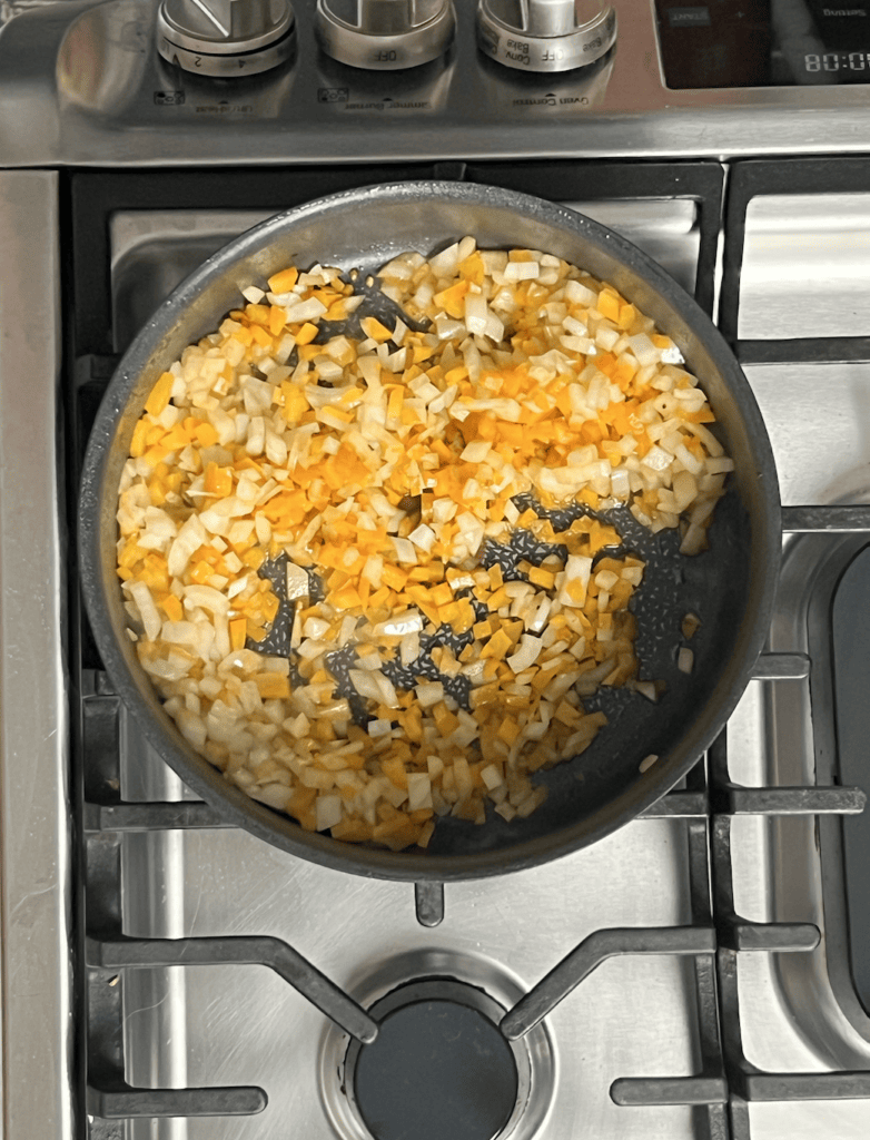 Diced onions and peppers in a pot.