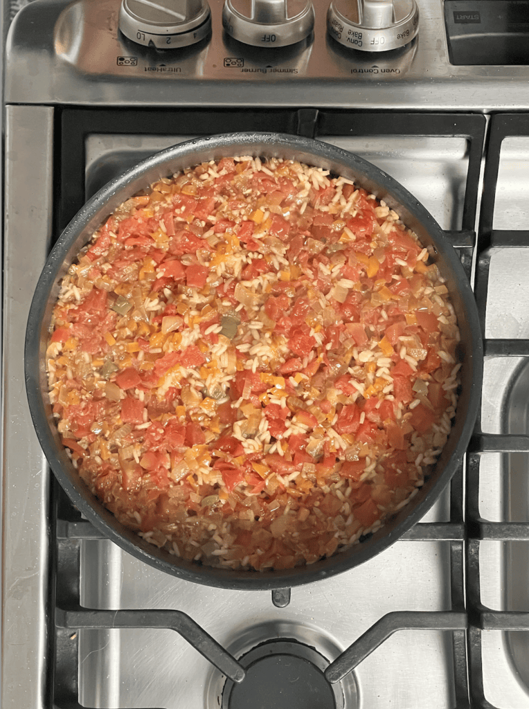 A pot of rice and beans with tomatoes.