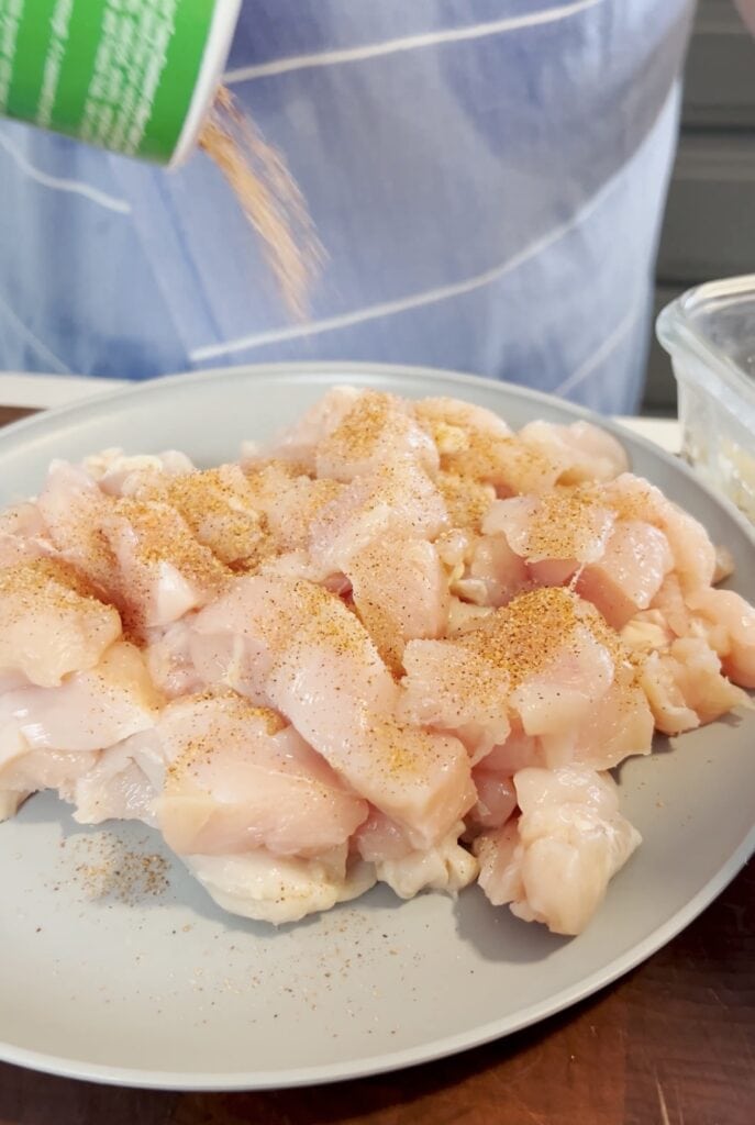 Seasoning chicken on a plate.