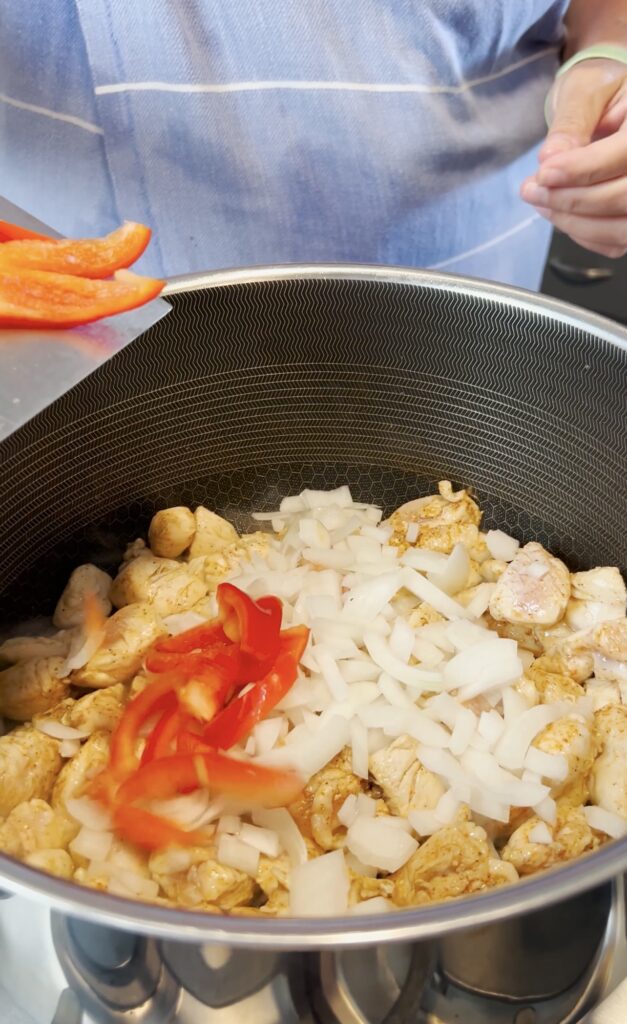 Peppers and onions in a pot.