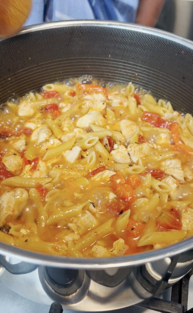 Cajun Chicken boiling in a pot.