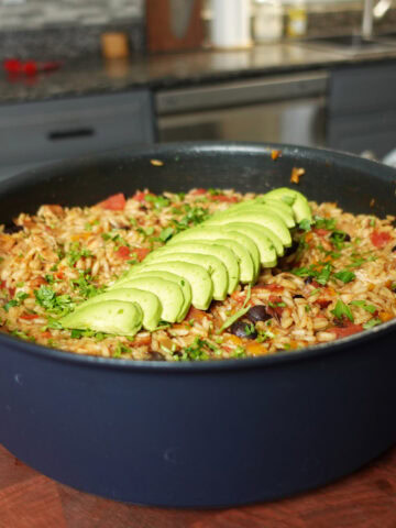 A large pot of rice and beans topped with avocado.