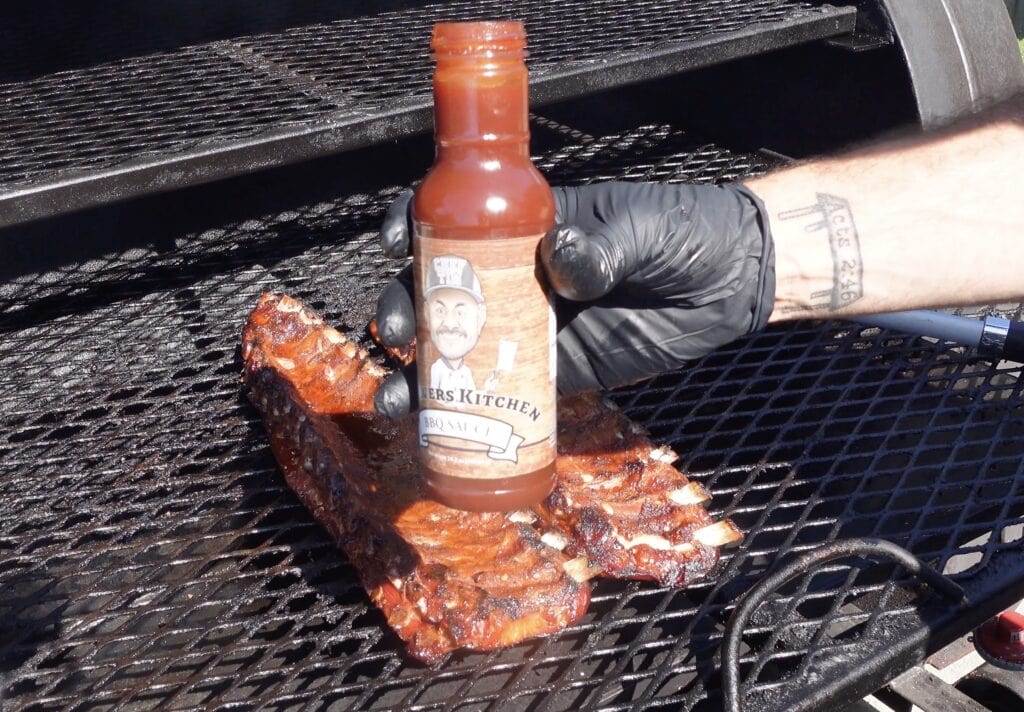 Tims BBQ Sauce going onto ribs on the smoker.
