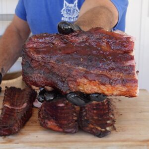 A rack of Smoked BBQ Pork Ribs with sauce on it.