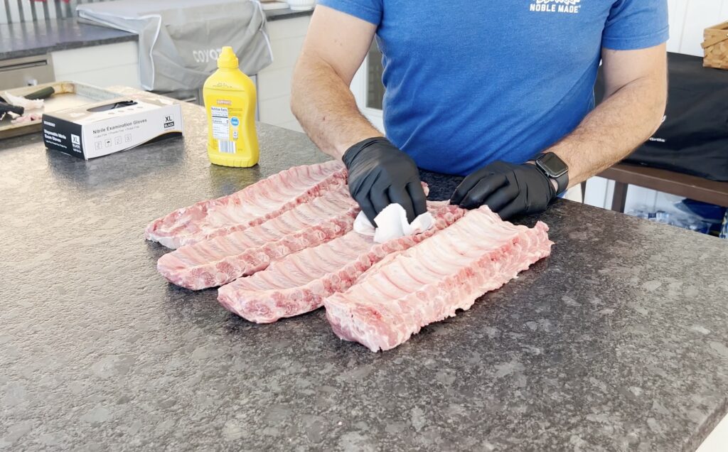 Seasoned pork ribs on a baking sheet.