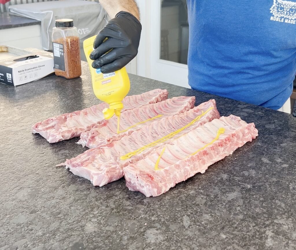 Mustard going onto ribs for a binder.
