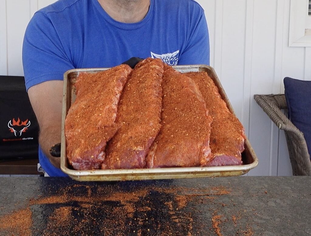Seasoned pork ribs on a baking sheet.