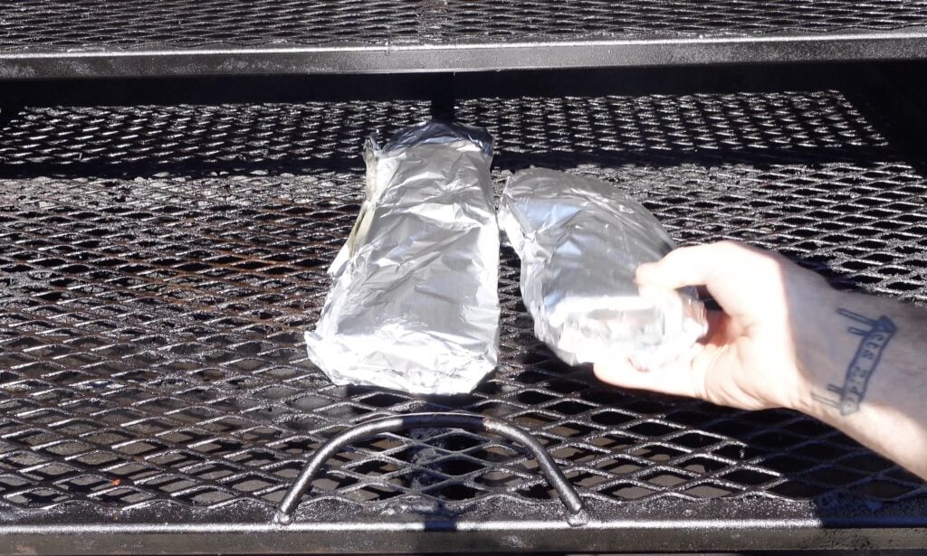 Smoked BBQ Pork Ribs wrapped in foil on the smoker.