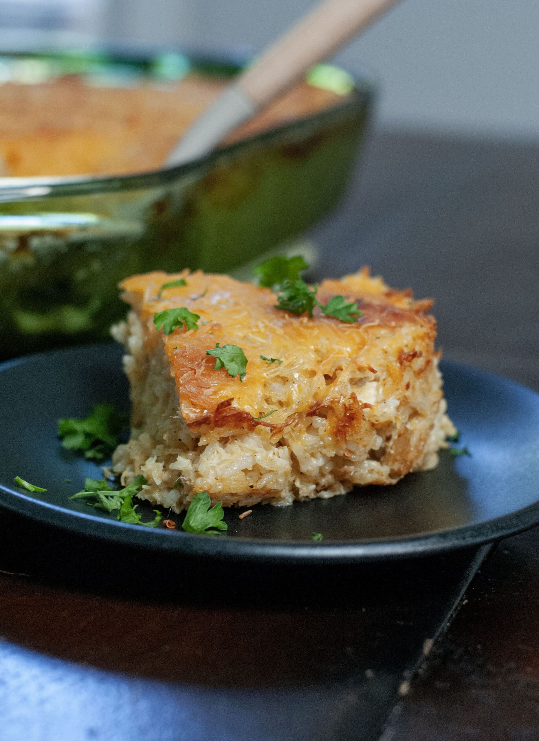 A slice of casserole with chicken and rice on a plate.
