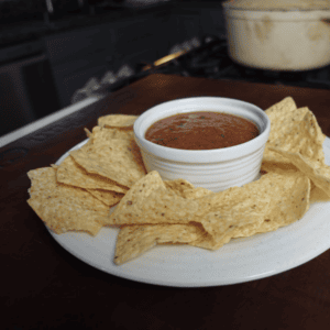 Salsa in a bowel surrounded by chips.
