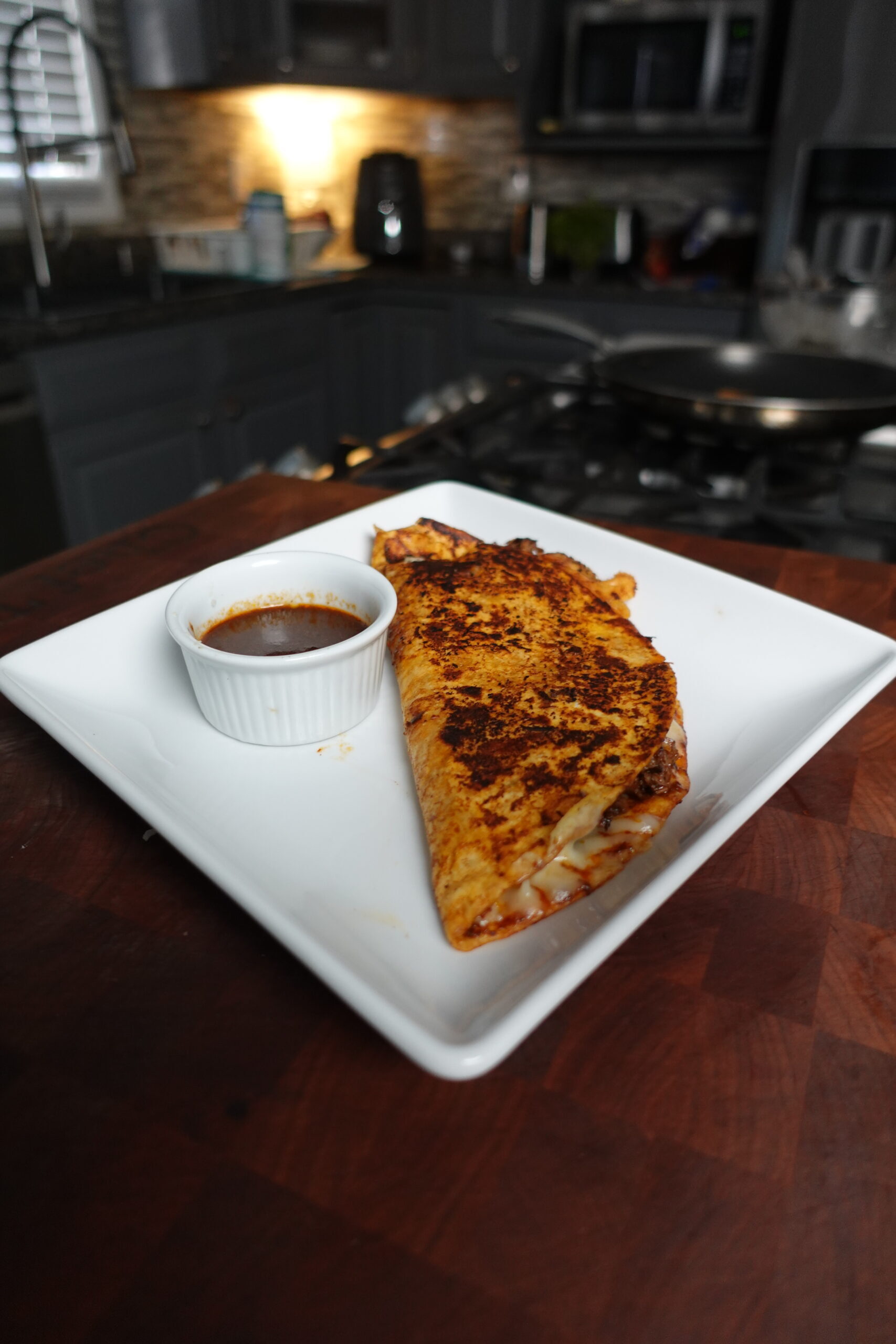 A plate with birria taco and sauce.