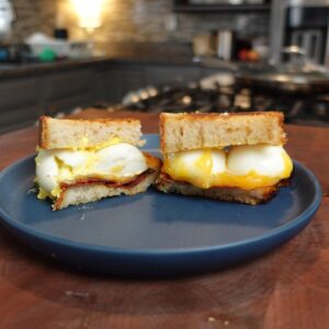 A deviled egg sandwich with bacon and cheese.