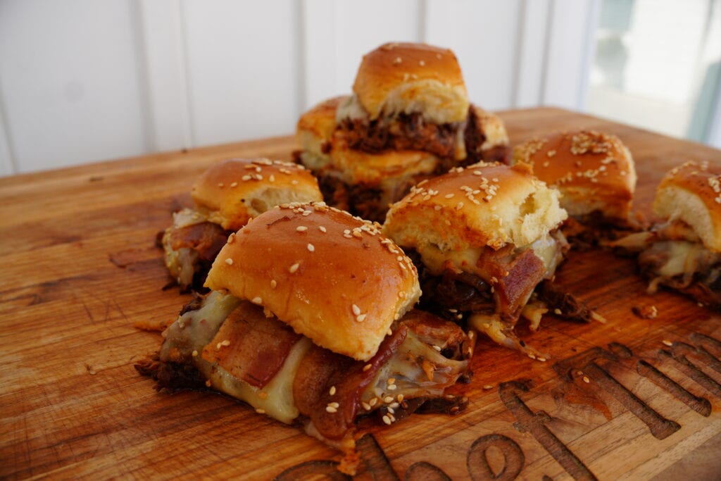 A stack of birria sliders on a cutting board.