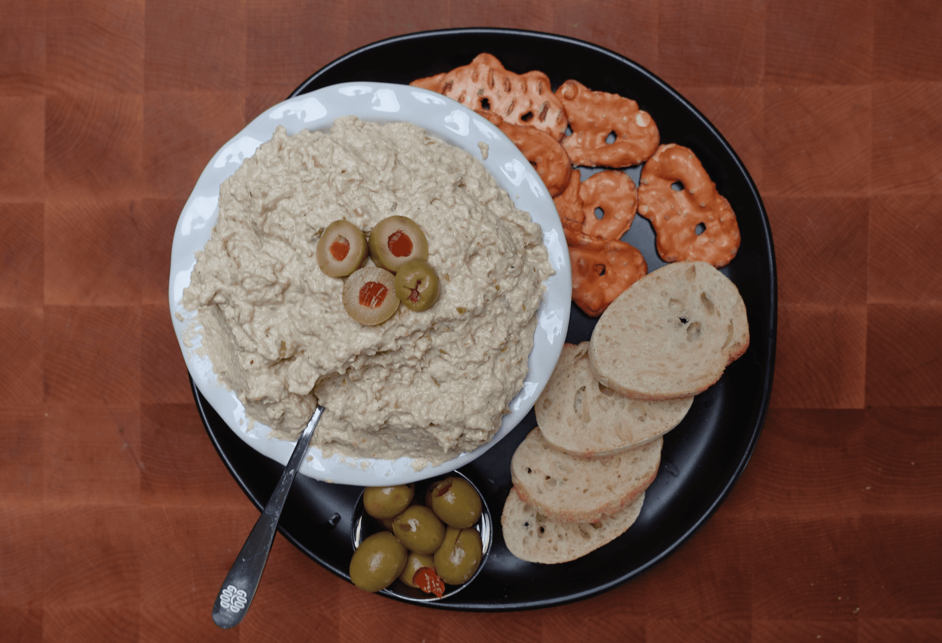 A plate of olive dip with bread.