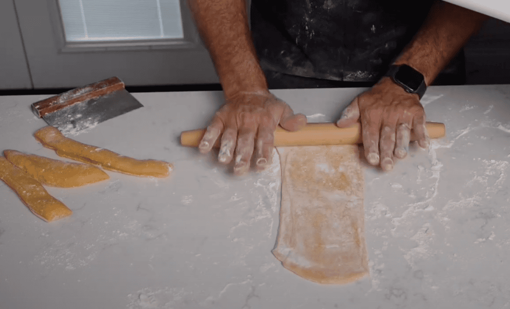 Rolling out a sheet of pasta for ravioli.