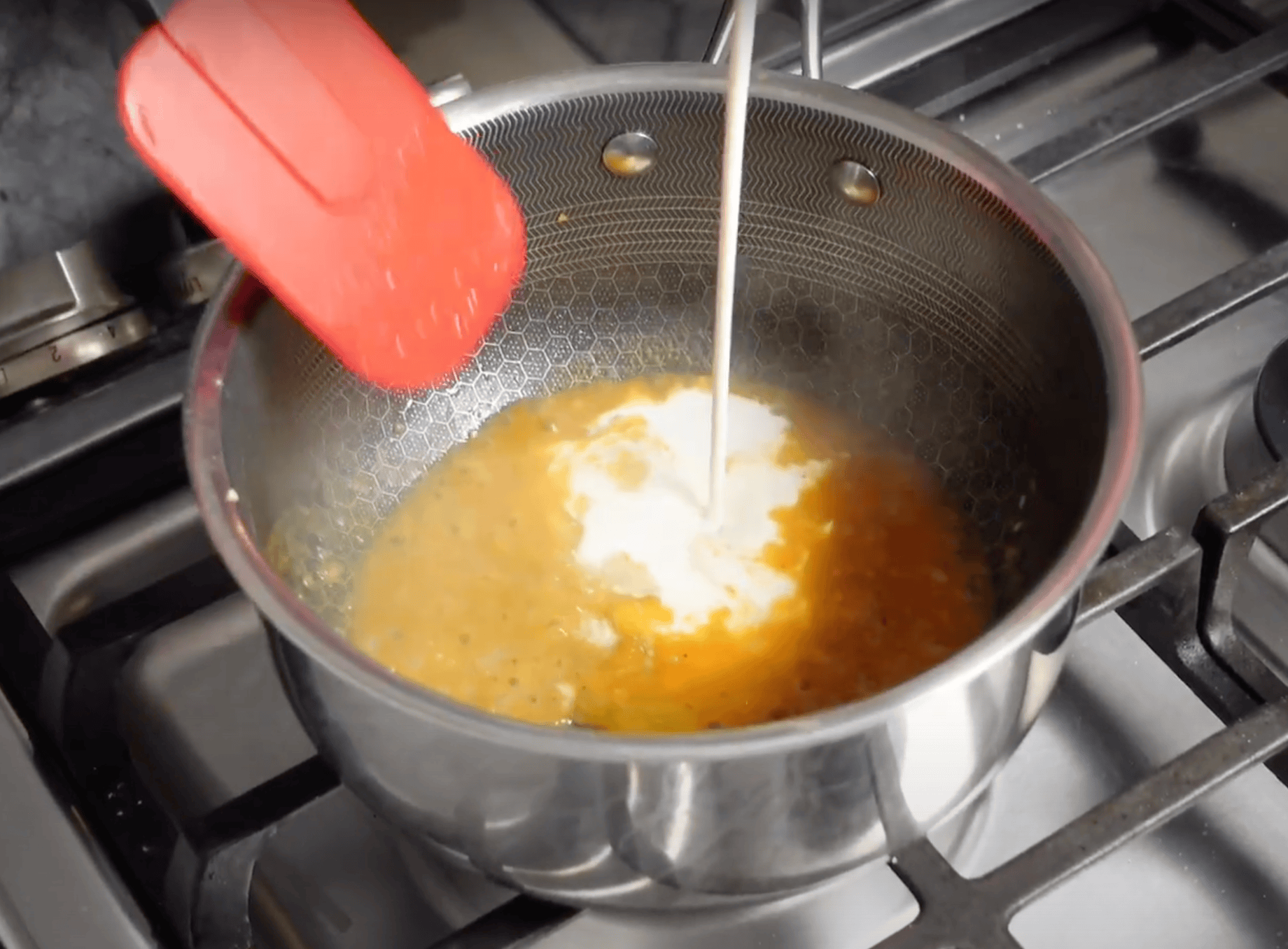 Heavy cream going into a pot for sauce.