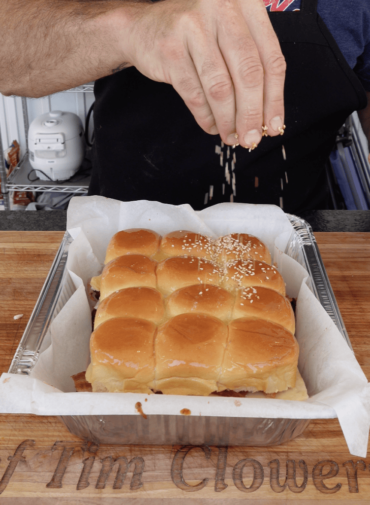 Sesame seeds going onto sliders.