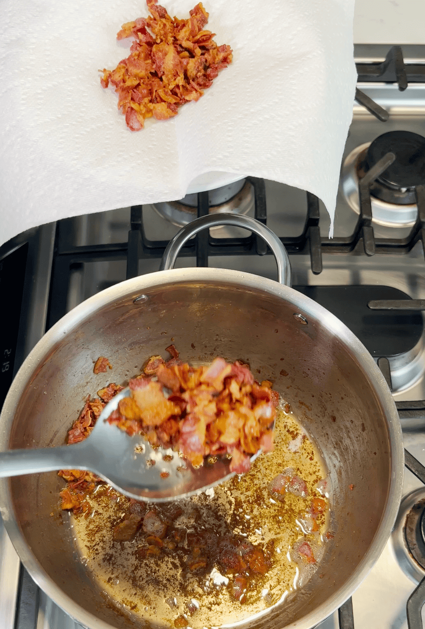 Chopping bacon over a stock pot.