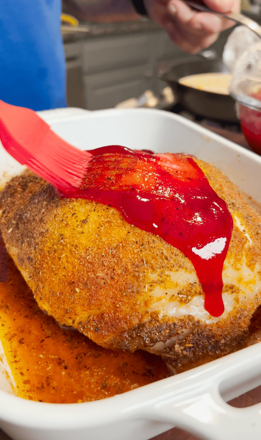 Cranberry sauce bushed over a turkey breast.