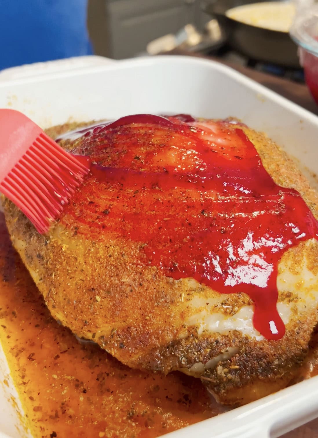 Cranberry glaze brushing onto a turkey breast.