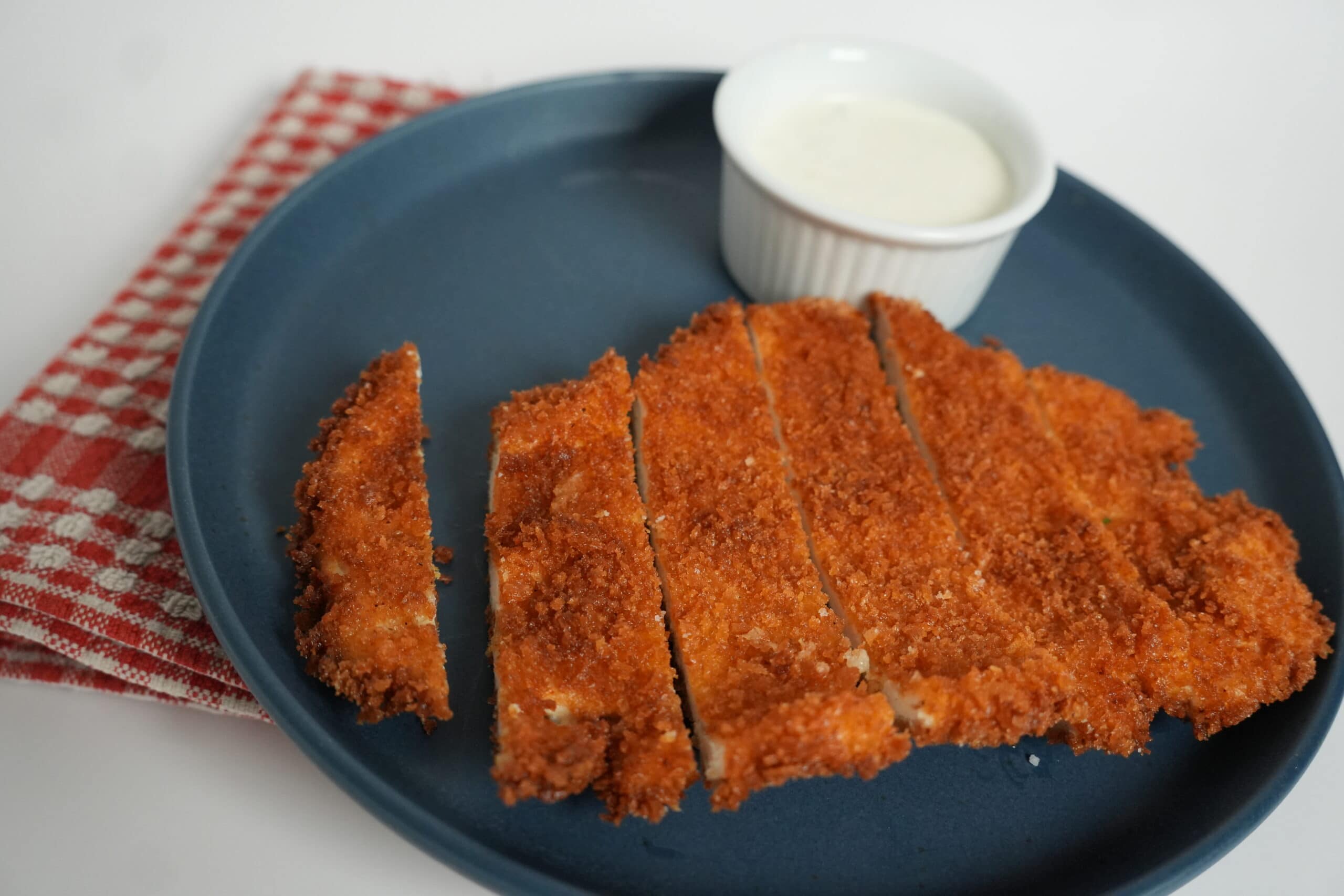 Sliced fried chicken tender on a plate. 