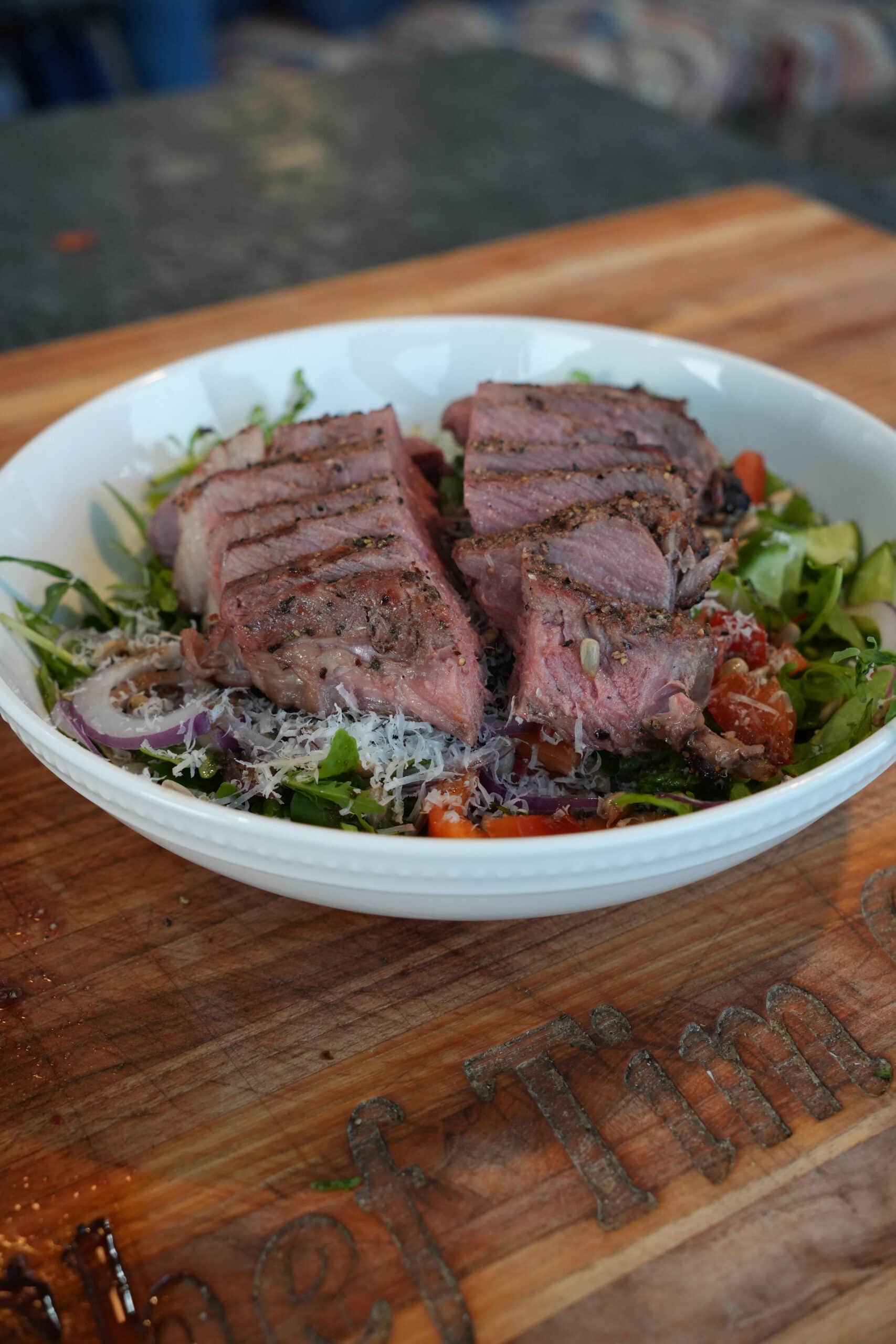 Slices of steak over a salad.