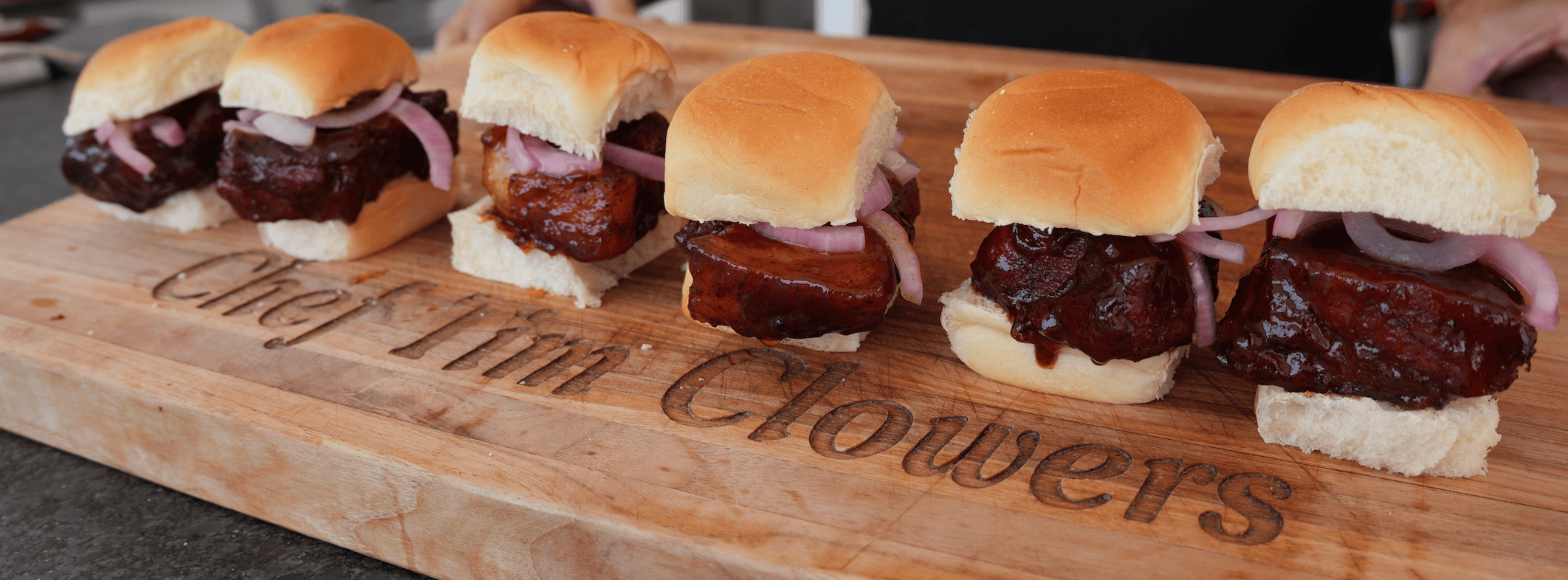 Mcrib sandwiches lined up on a cutting board.