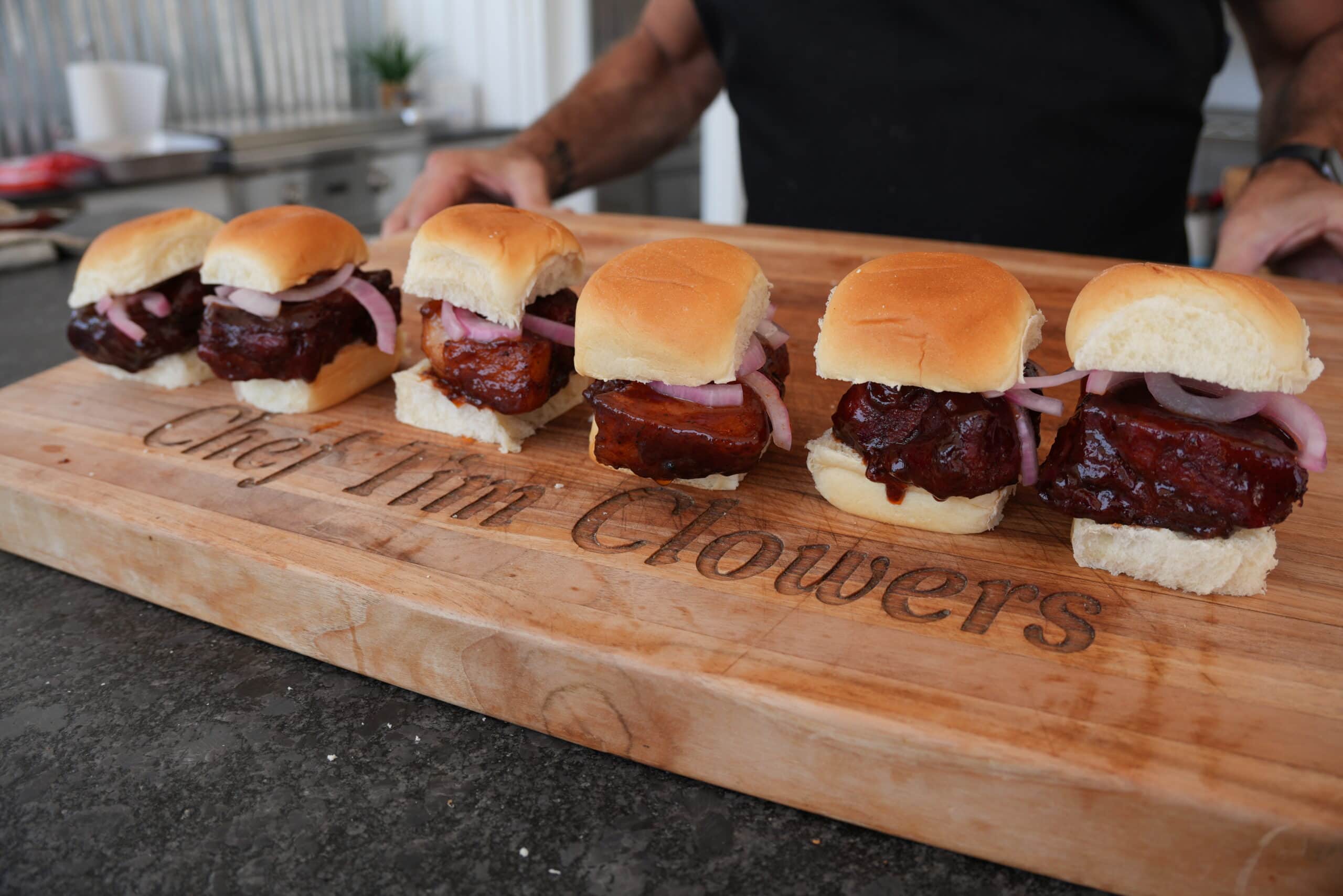 Lined up McRib Sandwiches on a cutting board.