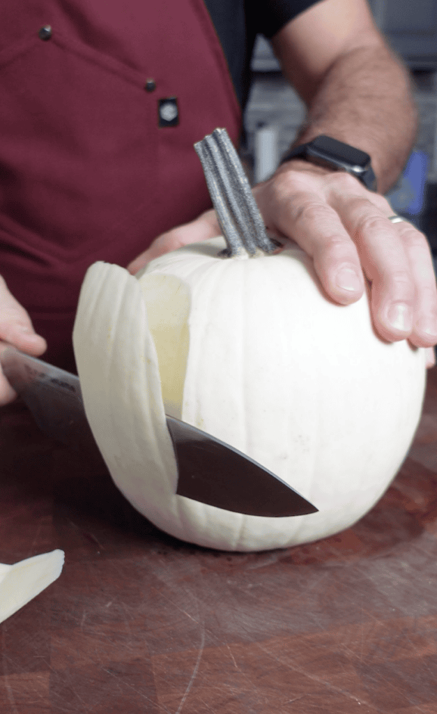 Slicing off the outside of a pumpkin.