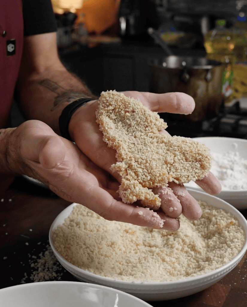 A chicken breast coated in bread crumbs.