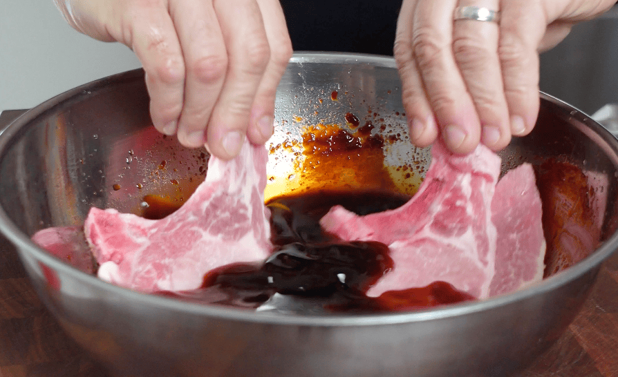Pork marinating a bowl.