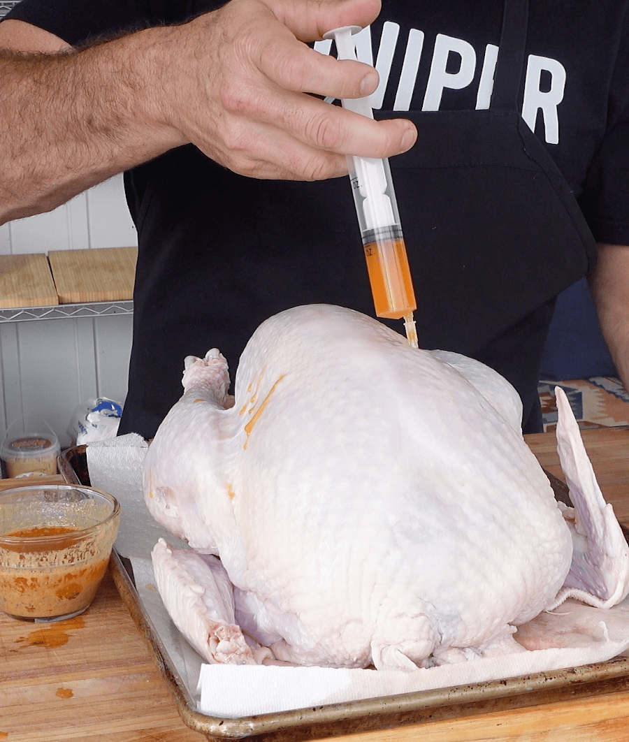Injecting turkey with mixture.