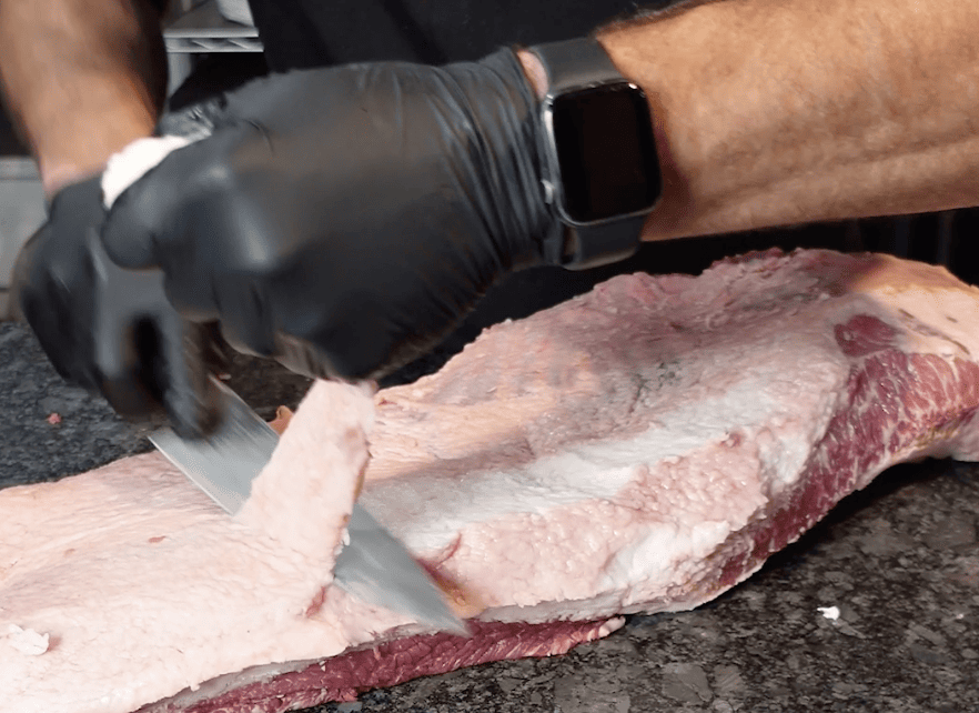 Trimming cap off of brisket.