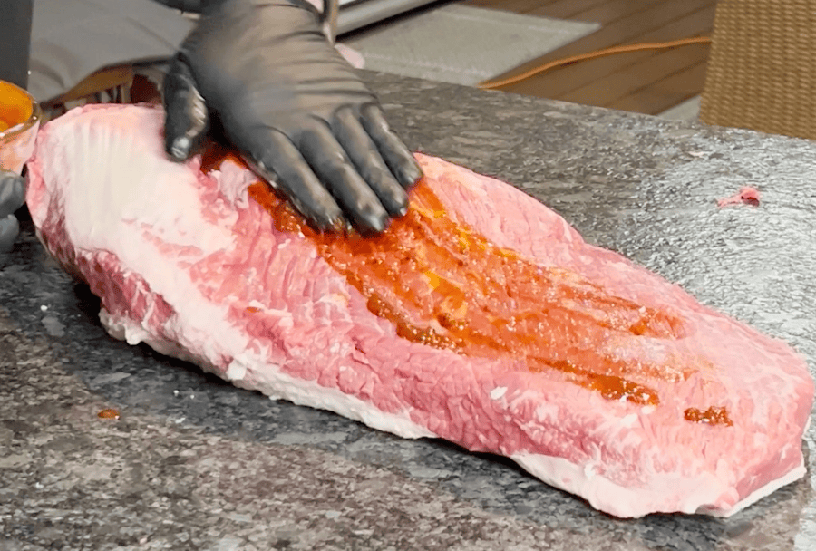 Rubbing paste onto brisket.